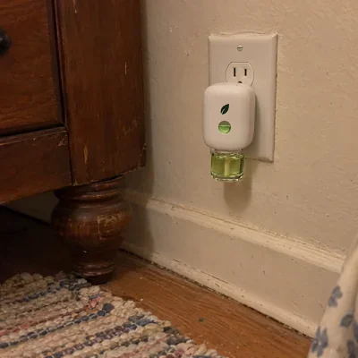 A buyer's phone photo: MintKeep plugged in low on her bedroom wall by an old dresser.