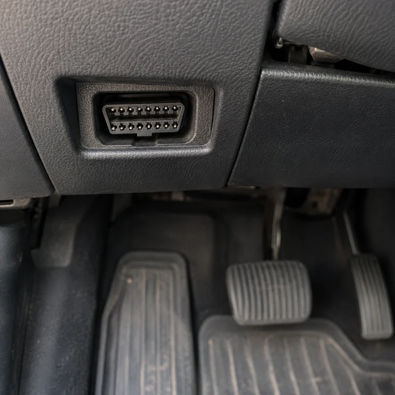 The port under the dash, above the pedals
