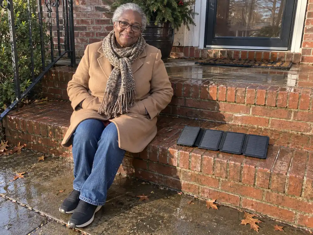 Annette sitting on her front steps after the rain, her TerraCell open on the step beside her in the sun
