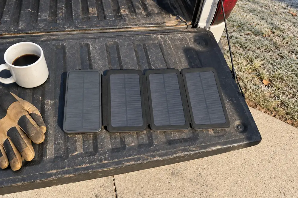 TerraCell opened flat on a pickup tailgate in low morning sun, frost on the lawn, the photographer's shadow across the tailgate