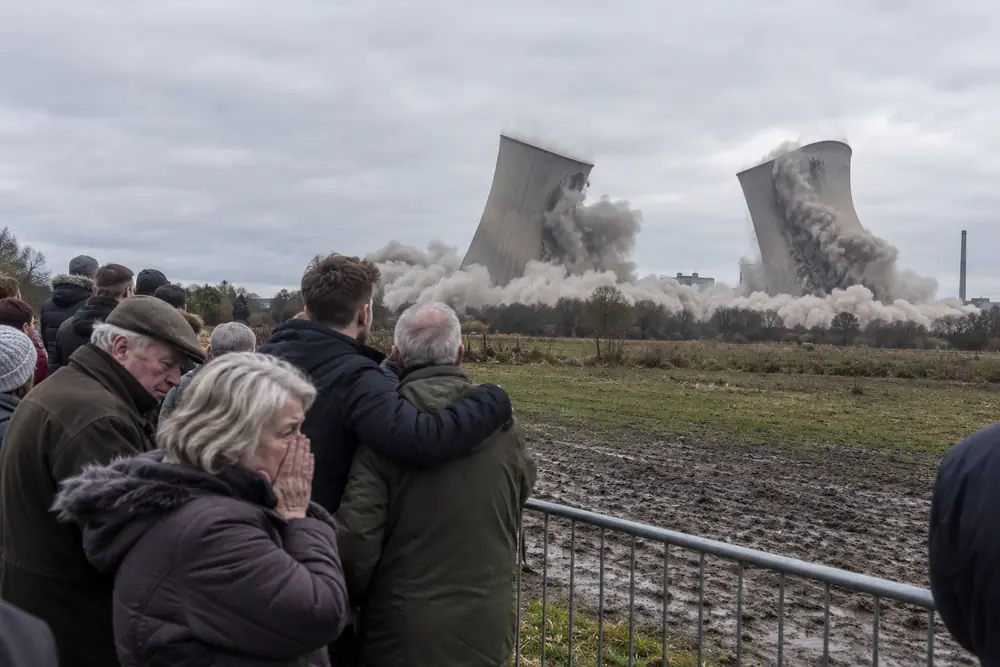 Locals watching two cooling towers fall in a cloud of dust