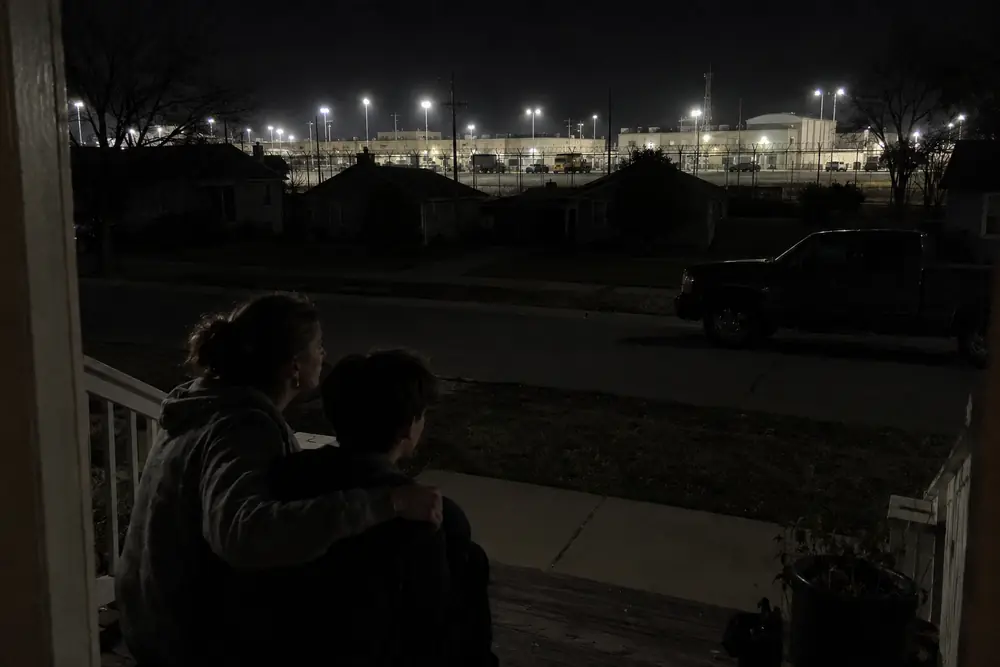 An American base lit up on its own power while the town outside is dark