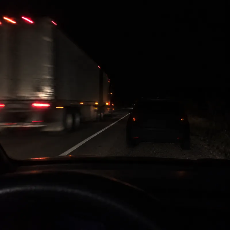 Through her windshield at night, her daughter's car is barely visible on the dark shoulder as a semi roars past it.