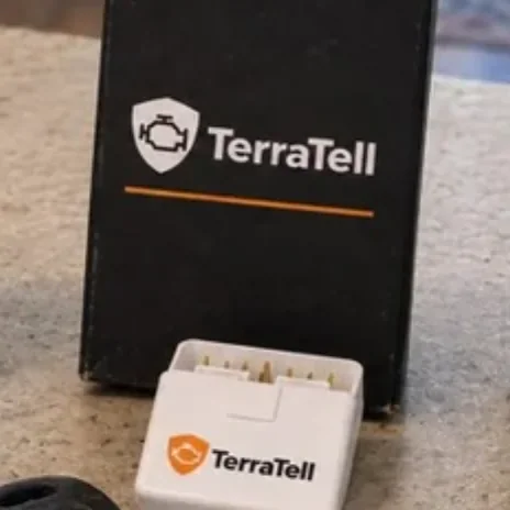 A small white TerraTell in front of its black TerraTell box on a kitchen counter.